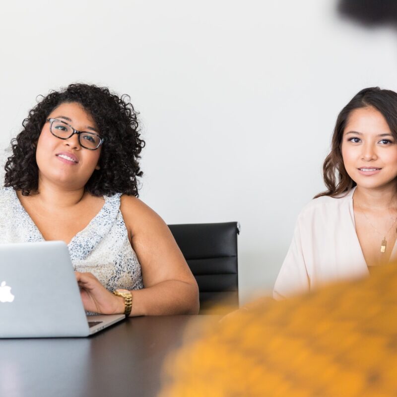 two women looking at person across the table